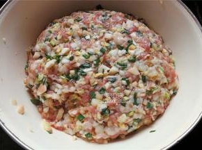最后把猪绞肉放入馅料中，撒入少许盐顺时针混合食材，香油滴入几滴混合。