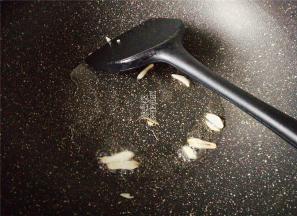鸡蛋盛出，再倒入少许油，把蒜瓣切片爆香。