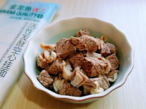 煮好的牛腩捞出用温水冲洗，将牛腩上的杂质冲洗干净。