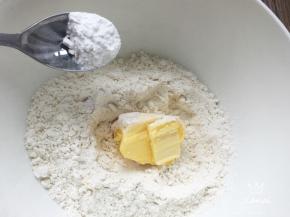 低粉加入细砂糖、泡打粉混合均匀，加入室温软化的黄油。用手搓至细小颗粒。