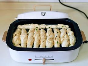 依次将花卷摆放到煎盘中，如图，盖上盖子醒10分钟。