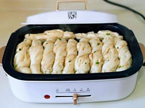 待花卷底部金黄时，从花卷的缝隙中倒入纯净水，水量到花卷的三分之一即可，盖上盖子低温焖，锅中的滋啦滋啦声音越来越小时，再焖2分钟至水分彻底干，打开盖子撒上葱花与黑芝麻，将多功能锅断电。