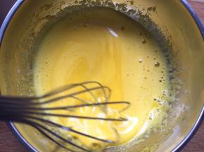 将纯牛奶趁热分三次倒入蛋黄中，边倒边搅拌