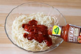 将面条捞出沥干水分放入碗里，倒入冠利牛排调味酱；