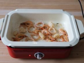 将虾、鱿鱼圈、鱿鱼花倒入锅内煸炒至变色；