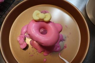 表面淋上融化后的巧克力，沾上小蝴蝶节，可爱的KT甜甜圈就完成了。