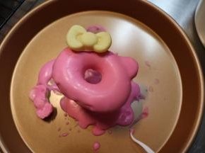 表面淋上融化后的巧克力，沾上小蝴蝶节，可爱的KT甜甜圈就完成了。