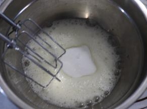 加入三分之一的细砂糖，打发至变白，泡沫变细腻的状态，加入剩余的二分之一的细砂糖