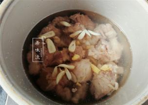 备一个高压锅，把沥干的排骨倒入，再放入切好的姜蒜和料酒，黑米醋。