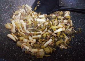 把切好的雪菜倒入锅中一起翻炒，撒入1撮白砂糖提鲜，降低咸味。