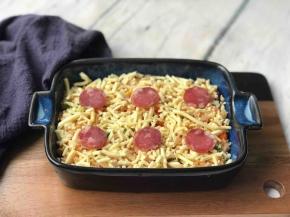 盛到烤碗中，上面铺层马苏里拉芝士碎、摆上腊肠片。