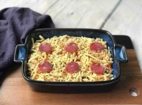 盛到烤碗中，上面铺层马苏里拉芝士碎、摆上腊肠片。