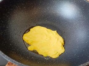 锅中倒入少许的油，七成热放入一勺面糊。