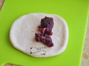 取一个面团擀开，放上红豆馅。