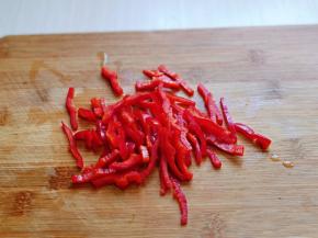 首先将红椒洗干净，再去根，去籽，切丝。