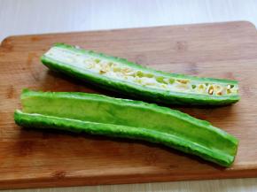 苦瓜去根，从中间切开，一切二，将瓤挖出来。