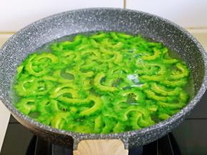 切好的苦瓜焯水: 锅中加入水烧开，滴几滴食用油，再倒入苦瓜，大火烧开立即捞出，过冷水，再捞出淋干水分。