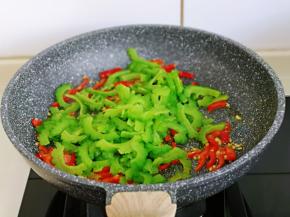 加入焯水的苦瓜，快速翻炒。