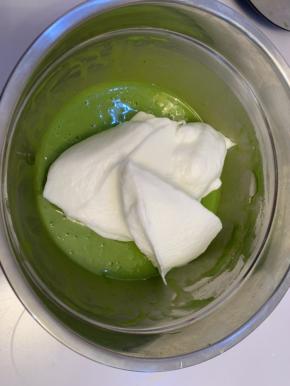 取三分之一蛋白，加入到菠菜面糊中，用刮刀翻拌均匀。