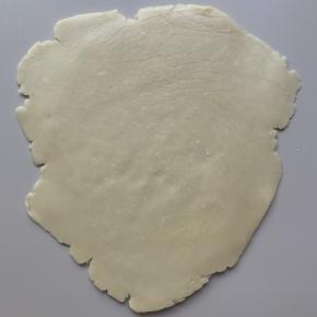 取出冷藏好的面团，隔着保鲜膜擀成稍有厚度的面皮。