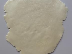 取出冷藏好的面团，隔着保鲜膜擀成稍有厚度的面皮。