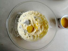 用电动打蛋器打发黄油，打发至颜色变浅，体积膨松，把鸡蛋液分3次倒入