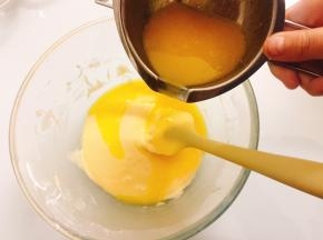 将放凉后的液态黄油，缓缓倒入面糊中，翻拌至完全融合