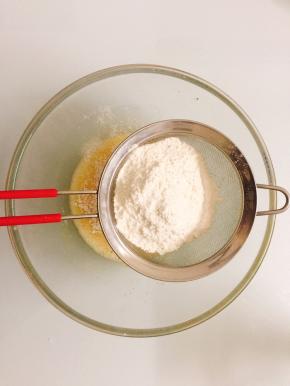 将低筋面粉和泡打粉过筛后，用硅胶刀翻拌均匀至无颗粒状