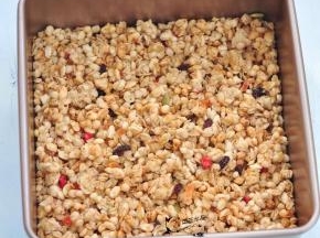 将即食麦片称量好，倒入正方形不沾模具中，压平整。