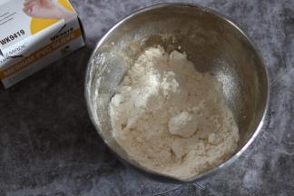 加入盐以及软化切小块的黄油，戴手套将黄油和面粉揉搓均匀