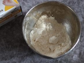 加入盐以及软化切小块的黄油，戴手套将黄油和面粉揉搓均匀