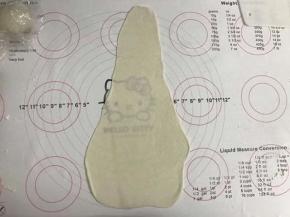 将面团擀成前小后大的薄片。