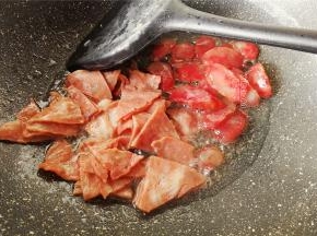 热锅倒入少量食用油，把切好的腊肠和培根下锅翻炒，煸出油脂。