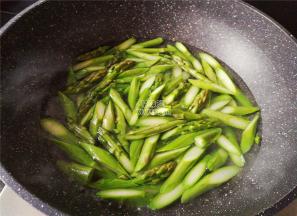 煮一锅沸水，把切好的芦笋段倒入锅中焯水一会，捞起沥干。
