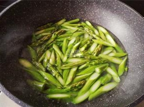煮一锅沸水，把切好的芦笋段倒入锅中焯水一会，捞起沥干。