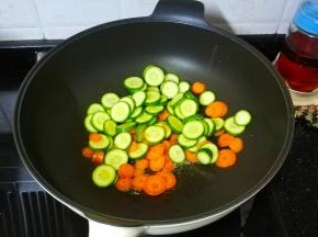 锅里热油，倒入青瓜红萝卜片炒1分钟