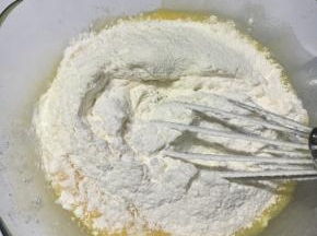 过筛低粉，奶粉，泡打粉至黄油鸡蛋糊中，拌匀即可，无需过多搅拌。