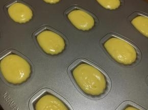 冷藏后的玛德琳面糊装入裱花袋，挤入玛德琳烤盘，学厨烤盘无需抹油，也无需撒粉。