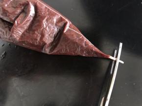 把巧克力装入裱花袋中，把袋子的尖尖剪一小口
