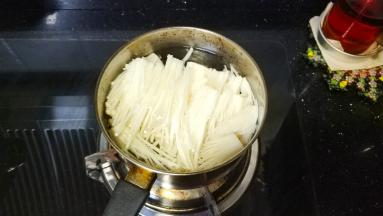 奶锅热水，水开后放入撕碎的金针菇焯至断生，捞出沥干水分