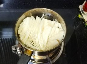奶锅热水，水开后放入撕碎的金针菇焯至断生，捞出沥干水分