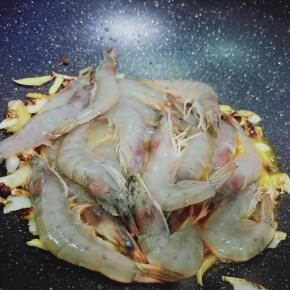 加入腌制好的对虾翻炒。