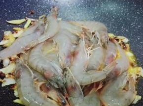 加入腌制好的对虾翻炒。