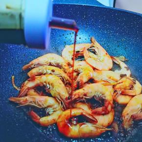 虾变红色后加入生抽与料酒，加少许糖调味，快速大火翻炒到虾肉全熟。