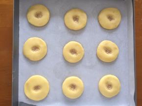 稍微压扁，中间用手指按出印子，压上白芝麻，不能放太密，会变大