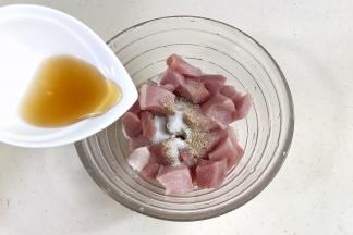 里脊肉冲洗干净，用刀切成约2~3厘米的块状，加入盐、胡椒粉和料酒拌匀腌制15分钟。