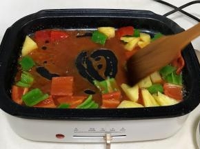 往锅中倒入食用油，倒入彩椒、菠萝翻炒一小会，加入调味汁。