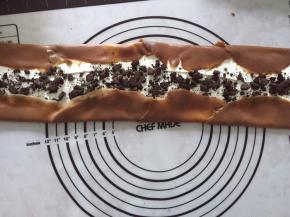 将奶油抹在中间，撒上奥利奥饼干碎，两边的多余的饼皮，向中间折叠