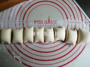把发酵好的面团取出，在案板上使劲揉，把面团里面的空气都揉出来，重新揉成光滑的面团。再搓成长条，切出32克小面团备用，剩余的切出8等份小面团，揉圆并盖上保鲜膜