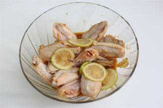 香柠用盐揉洗一下外表，取半个切成薄片放入鸡翅内，抓匀腌制2小时。